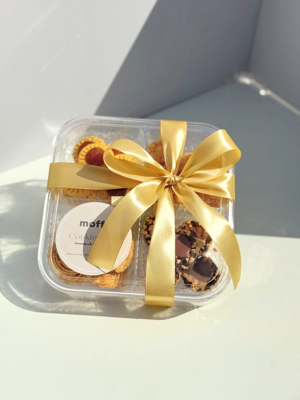 Moffa cookie gift box tied with a gold satin ribbon
